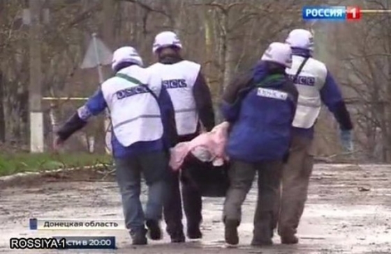 Труп, которого уносили на самодельных носилках четыре наблюдателя ОБСЕ