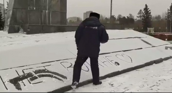 Мент стирает надпись «Нет войне»